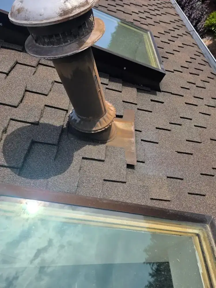 Flashing repair in progress on a composition roof
